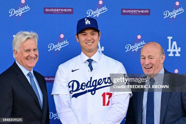 Japanese baseball player Shohei Ohtani poses with Mark Walter , owner of the Los Angeles Dodgers, and Andrew Friedman , president of baseball...