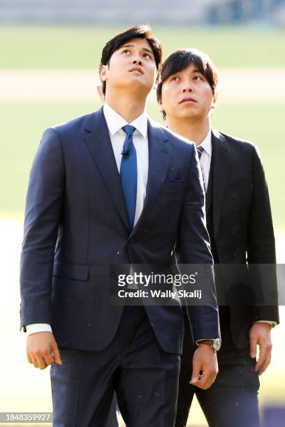 Shohei Ohtani, left, walks in with his translator Ippei Mizuhara before the Los Angeles Dodgers introduce Ohtani as the newest member of the team...