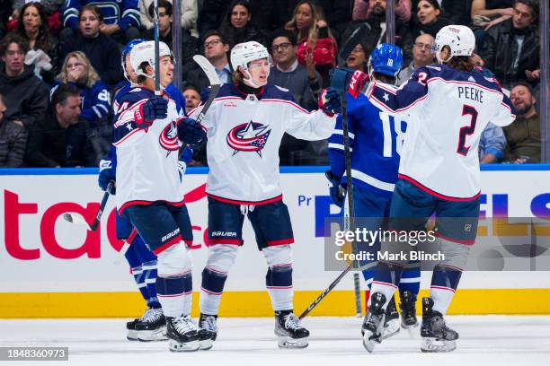 Kent Johnson of the Columbus Blue Jackets celebrates his goal against the Toronto Maple Leafs with teammates Cole Sillinger and Andrew Peeke during...