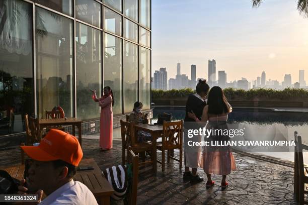 Tourists take photos at a hotel amid moderate levels of air pollution in Bangkok on December 15, 2023.