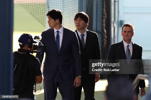 Shohei Ohtani and Ippei Mizuhara of the Los Angeles Dodgers and agent Nez Balelo walk in before the Shohei Ohtani Los Angeles Dodgers Press...