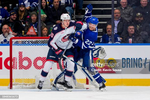 Jake McCabe of the Toronto Maple Leafs battles against Dmitri Voronkov of the Columbus Blue Jackets during the second period at the Scotiabank Arena...