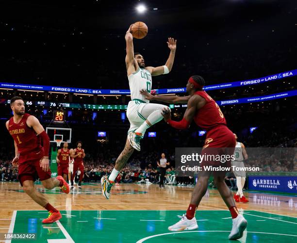 Jayson Tatum of the Boston Celtics takes off for a dunk against Caris LeVert of the Cleveland Cavaliers during the second half at TD Garden on...
