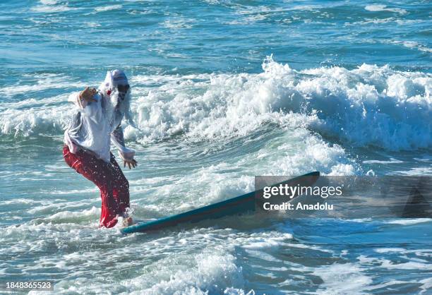 Man dressing up as a Santa Claus surfs at the city's beaches in Rio de Janeiro, Brazil on December 14, 2023.