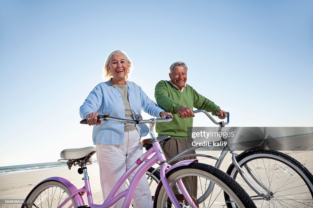 Senior couple with bicycles on beach