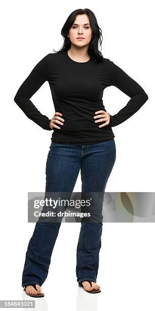 serious young woman standing with hands on hips - woman in black trousers stock pictures, royalty-free photos & images