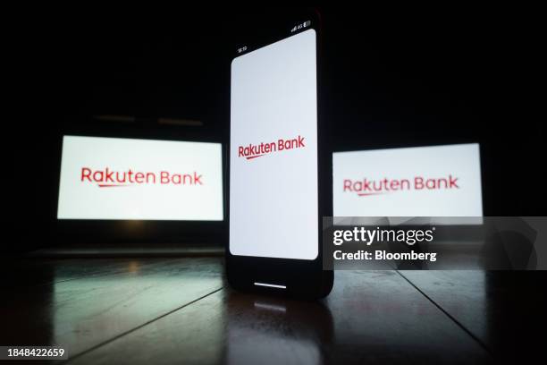 The Rakuten Bank Ltd. Logo on a smartphone and laptop computer screen arranged in Yokohama, Japan, on Wednesday, Dec. 13, 2023. Founded by former...