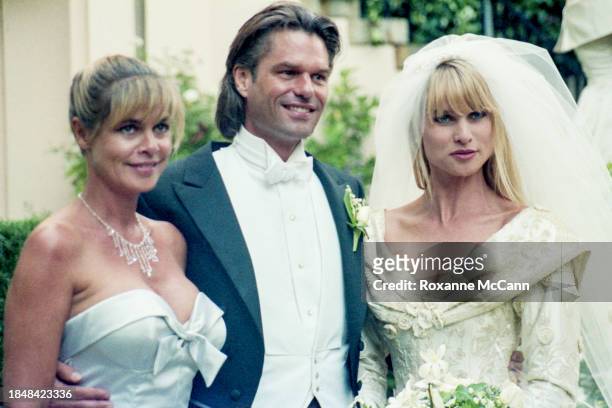 Harry Hamlin and Nicollette Sheridan pose for the camera on their wedding day with Nicollette's mother Sally Sheridan Savalas wearing a blue...