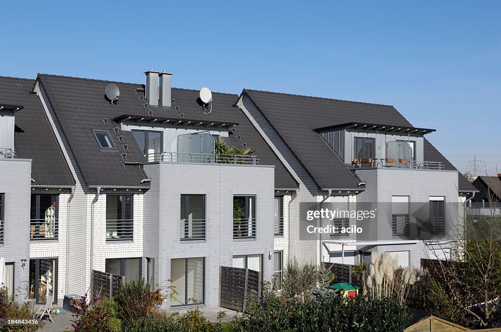 A block of modern attached houses with terrace and backyard