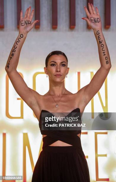 In this handout photo released by El Gouna Film Festival, Austrian-Egyptian actress Amira El Sayed holds up her hands to show messages reading 'End...