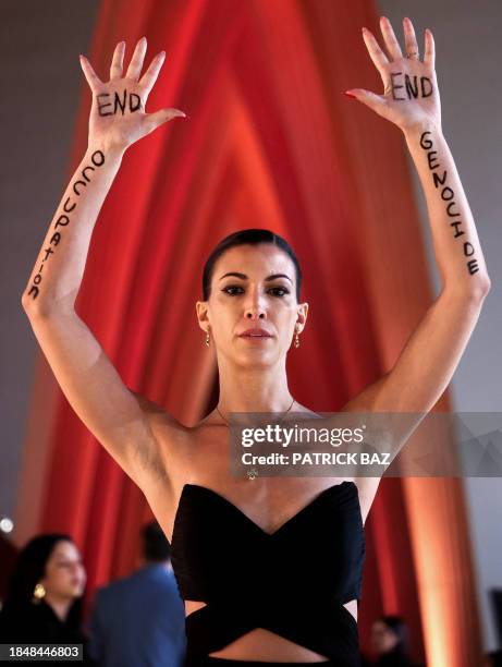 In this handout photo released by El Gouna Film Festival, Austrian-Egyptian actress Amira El Sayed holds up her hands to show messages reading 'End...