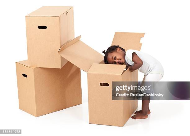 lovely baby girl rummaging in a cardboard box. - baby products stock pictures, royalty-free photos & images