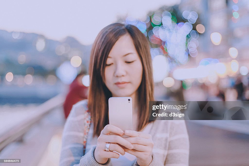 Pretty Asian woman using her smartphone