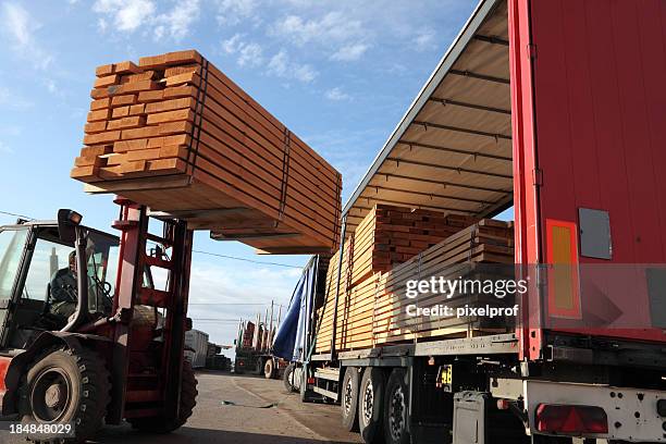 forklift loading truck - construction material stockfoto's en -beelden