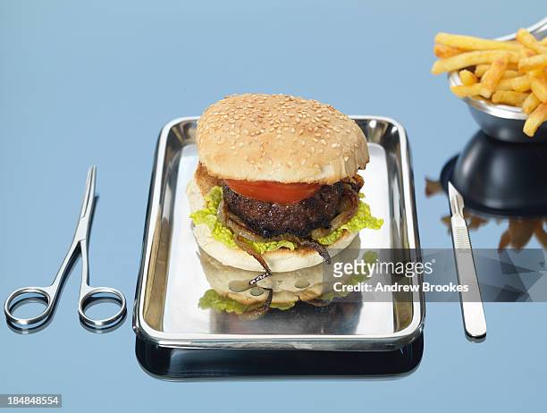 still life of beef burger on surgical tray - surgical tray stock pictures, royalty-free photos & images