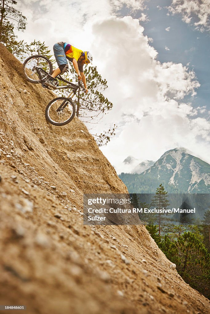 Mountain biker riding down steep mountainside