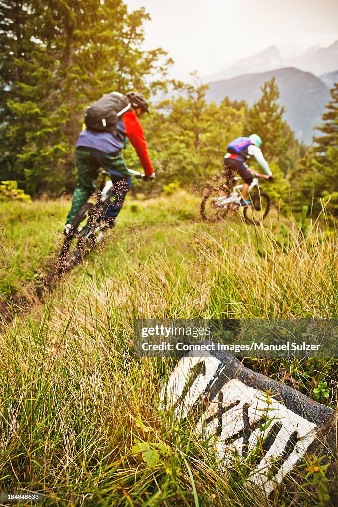 Mountain biking couple riding dirt trail