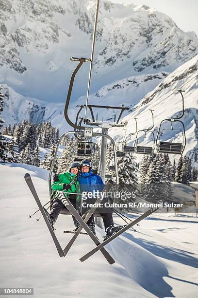 couple riding ski lift, warth, vorarlberg, austria - couple ski lift stockfoto's en -beelden