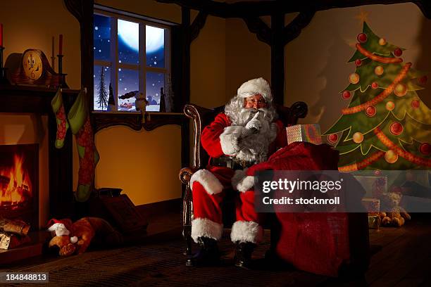santa hält eine tasche voll ofchristmas geschenke - grotte stock-fotos und bilder