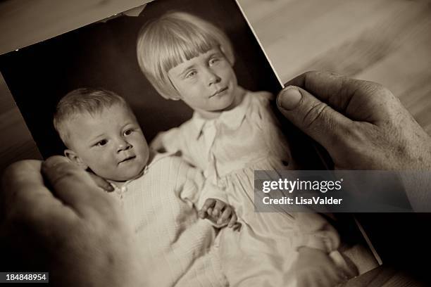 individual holding picture with childhood memories - old brother stock pictures, royalty-free photos & images