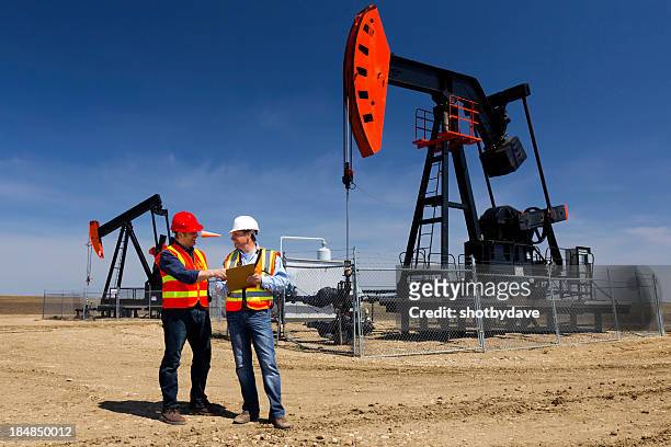 pumpjacks y los trabajadores - oil field fotografías e imágenes de stock