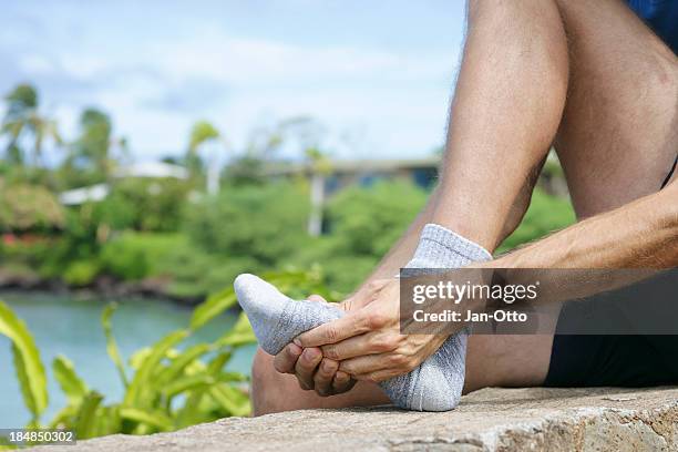 jogger massaging the metatarsal area of the foot - gout stockfoto's en -beelden