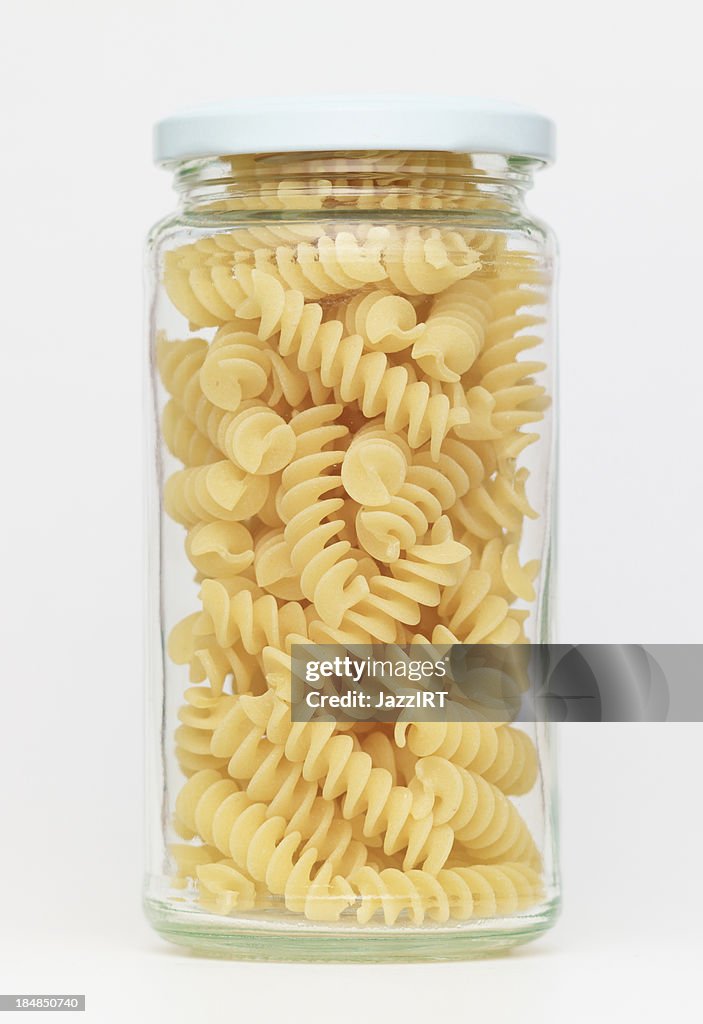 Pasta en frasco de vidrio sobre un fondo blanco