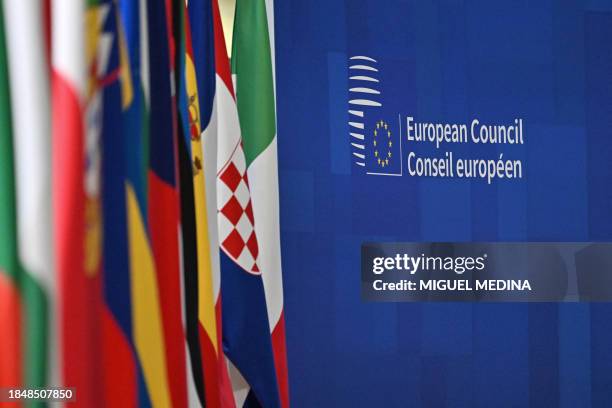 This photograph taken on December 15 shows lined up flags at the European headquarters during the European Union summit, in Brussels. EU chief...