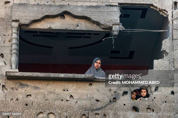 Palestinian woman and children looks on following Israeli bombardment on Rafah, in the southern Gaza Strip, on December 15 amid continuing battles...