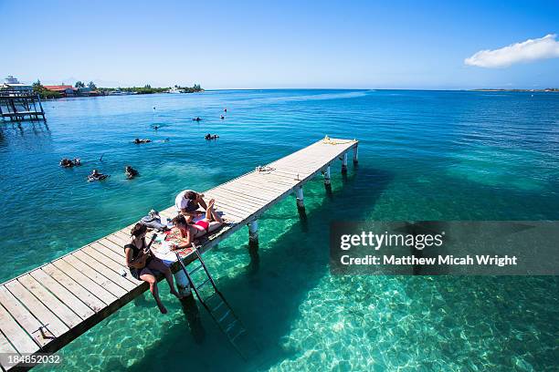 girls play music in the sun on a utila dock. - honduras stock pictures, royalty-free photos & images