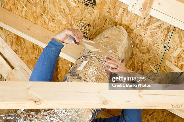worker insulating an attic vent duct with aluminum foil tape - attic stock pictures, royalty-free photos & images