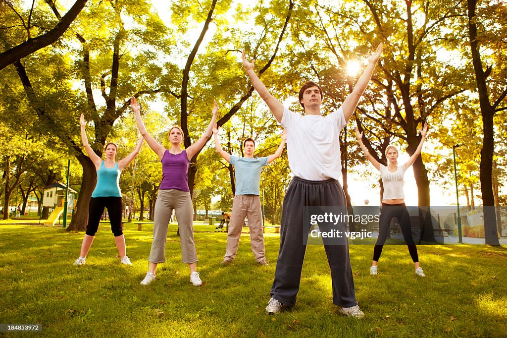 Gruppo di giovani praticare Tai Chi all'aperto