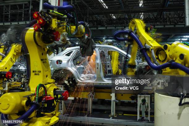 Robot arms work on the assembly line of Huawei AITO new energy sports utility vehicles at an intelligent factory of Seres Group Co., Ltd on November...