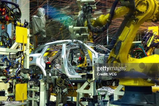 Robot arms work on the assembly line of Huawei AITO new energy sports utility vehicles at an intelligent factory of Seres Group Co., Ltd on November...