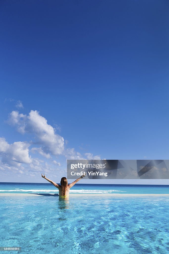 Woman on Vacation enjoying Infinity Pool in Caribbean Resort Hotel