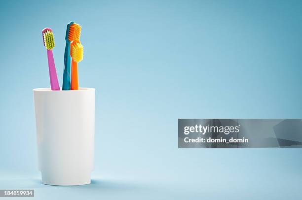 trois couleurs douces brosses à dents blanches sur fond bleu mug - toothbrush photos et images de collection