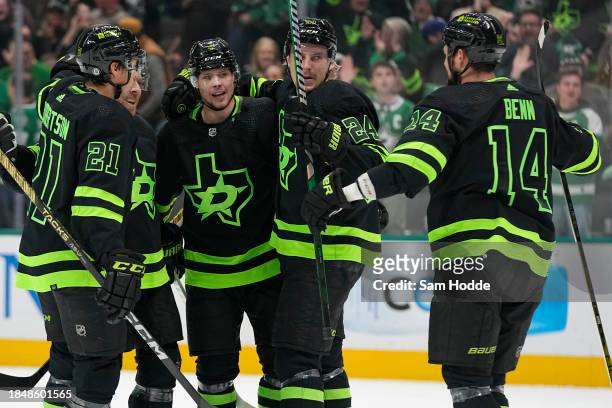 Miro Heiskanen of the Dallas Stars is congratulated by Jason Robertson, Roope Hintz, and Jamie Benn after scoring a goal during the first period...