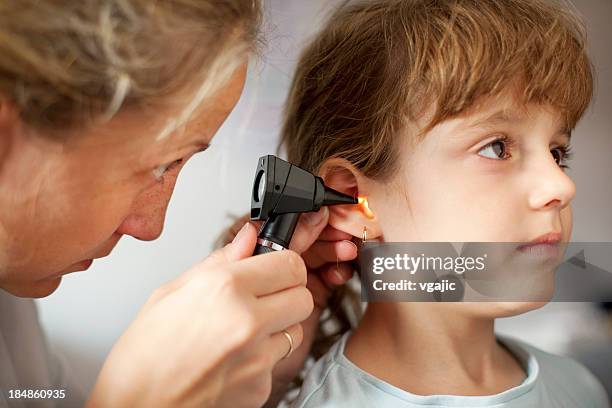 junges mädchen erhält hno-untersuchung von kinderarzt - ear exam stock-fotos und bilder