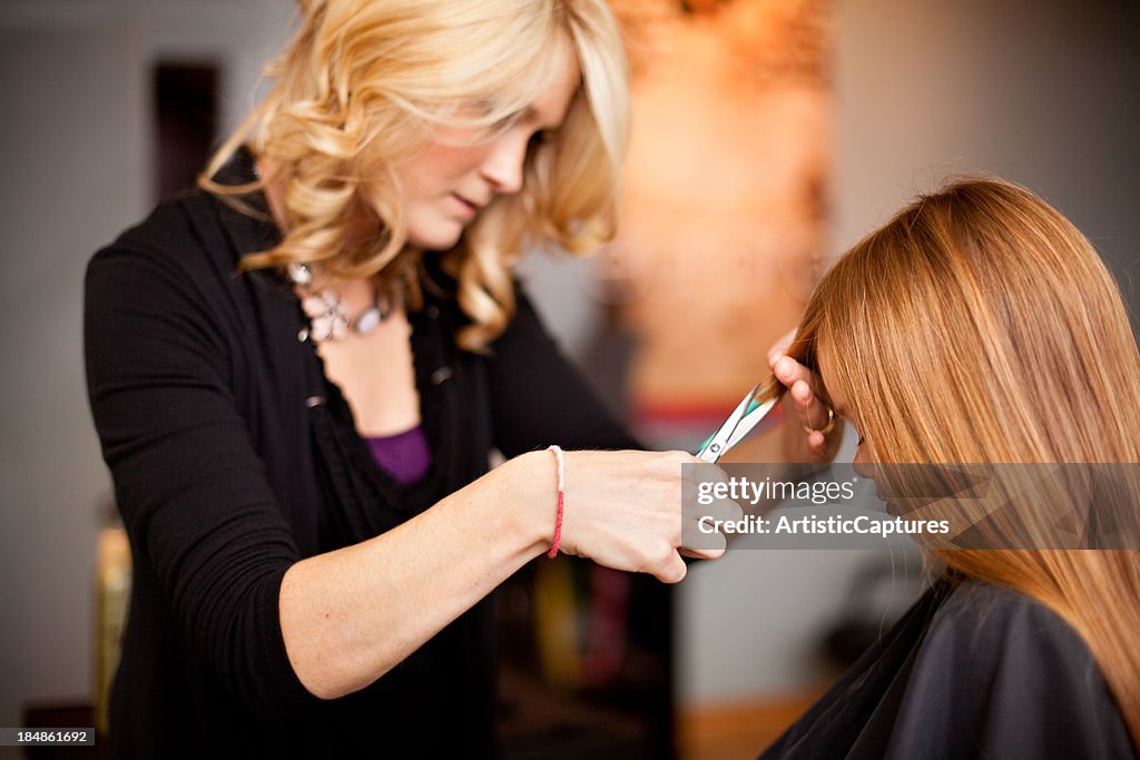 Little Red-Haired Girl Getting Haircut in Salon