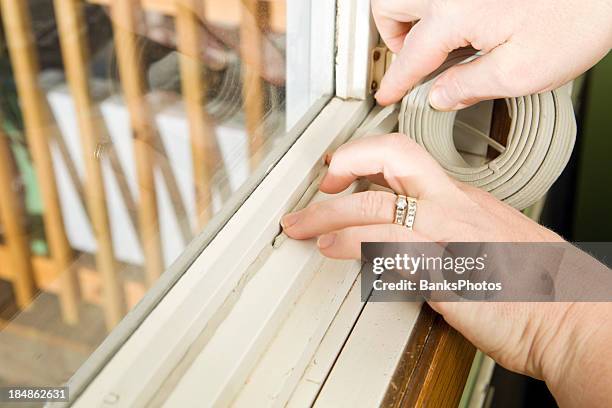 hands applying weather seal caulk to window frame - caulk stock pictures, royalty-free photos & images