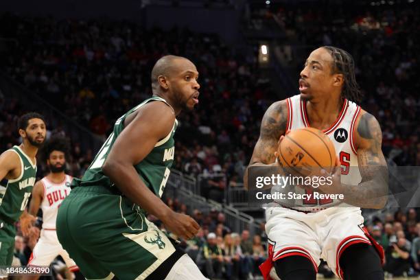 DeMar DeRozan of the Chicago Bulls is defended by Khris Middleton of the Milwaukee Bucks during the first half of a game at Fiserv Forum on December...