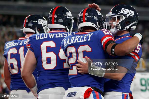 Saquon Barkley of the New York Giants celebrates with Tommy DeVito after scoring a five yard touchdown against the Green Bay Packers during the...