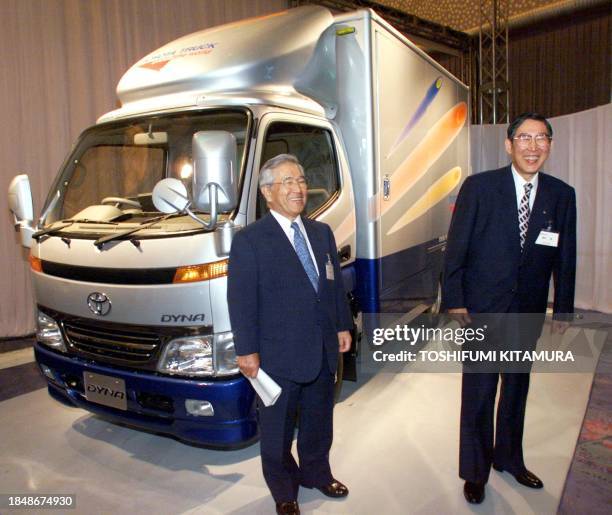 Toyota motors Chairman Shoichiro Toyoda and President Hiroshi Okuda share a smile while posing for photographers next to their new trucks', Dyna and...