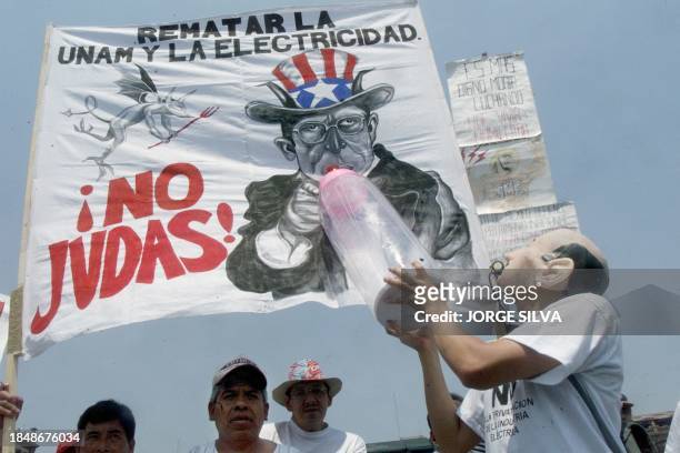 Un trabajador disfrazado con la cara del ex presidente de Mexico Carlos Salinas da de "amamantar" a una imagen del presidente de Mexico Ernesto...