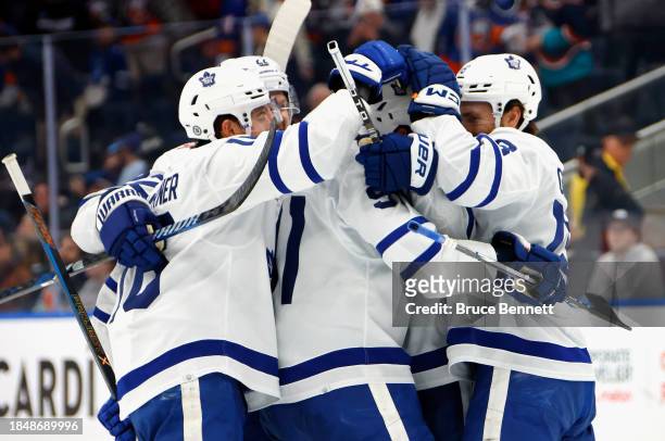The Toronto Maple Leafs celebrate the 1000th point by John Tavares against the New York Islanders at UBS Arena on December 11, 2023 in Elmont, New...