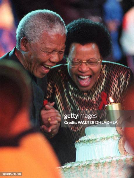 President Nelson Mandela blows out a candle with his new wife Graca Machel 19 July at a banquet to celebrate his 80th birthday at Gallagher Estates...