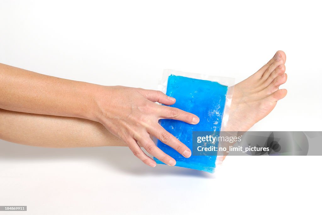 Blue gel pack applying on an ankle on white background