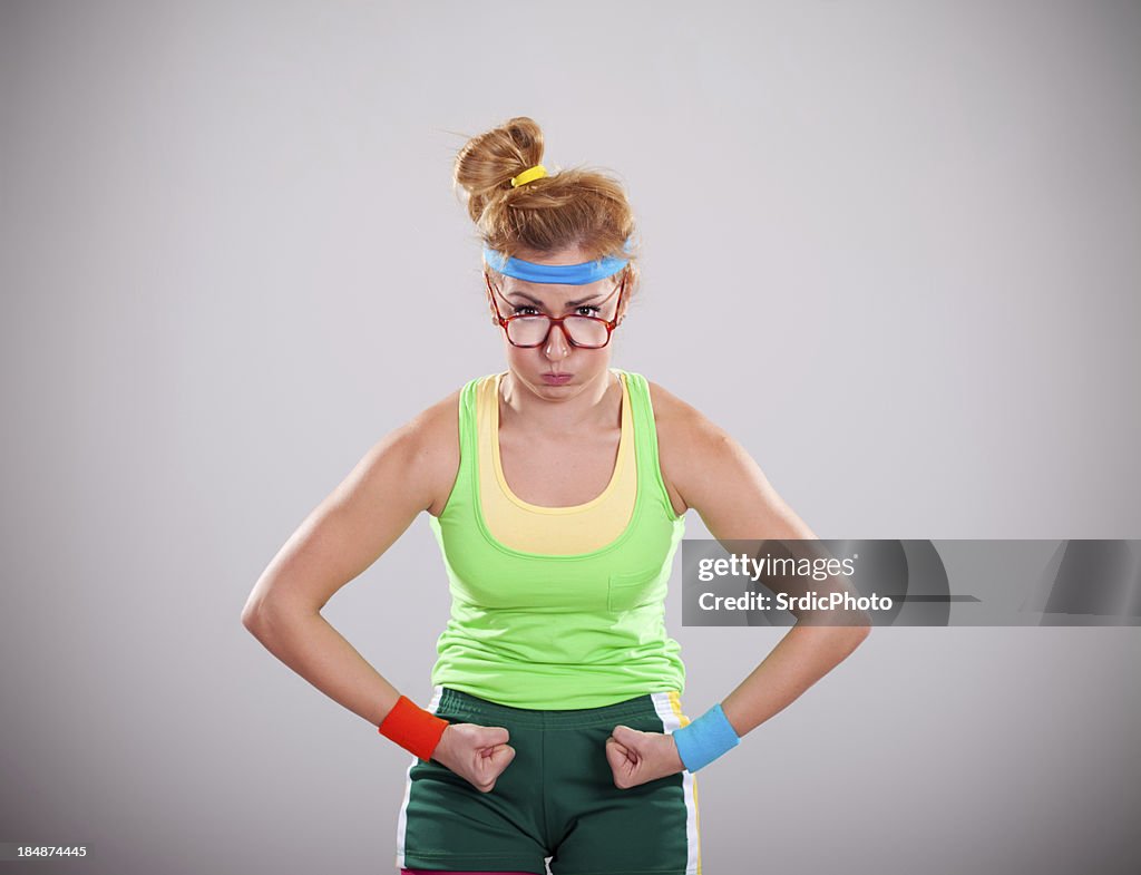 Strongest female geek flexing biceps muscles on gray background