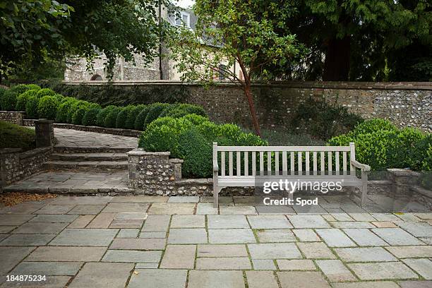 wooden bench on old stone patio - stone wall garden stock pictures, royalty-free photos & images