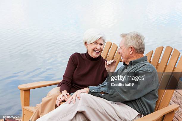 senior couple sitting by water - wood deck top view stock pictures, royalty-free photos & images